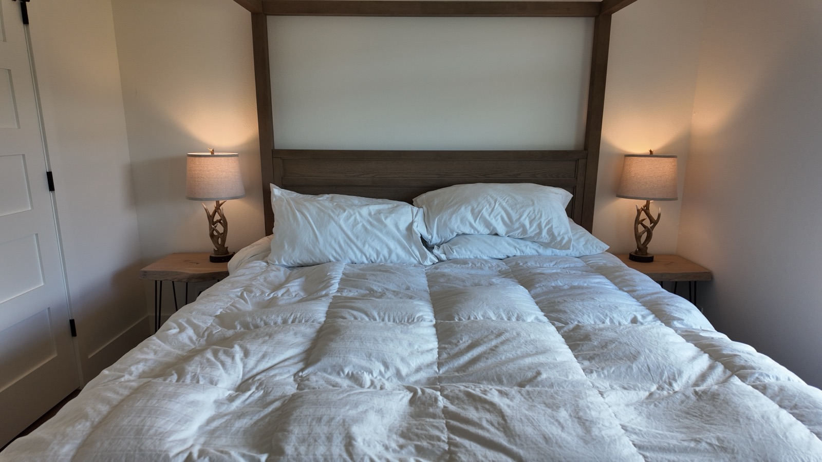 Second bedroom with a wood canopy king bed, antler bedside lamps and a canyon view