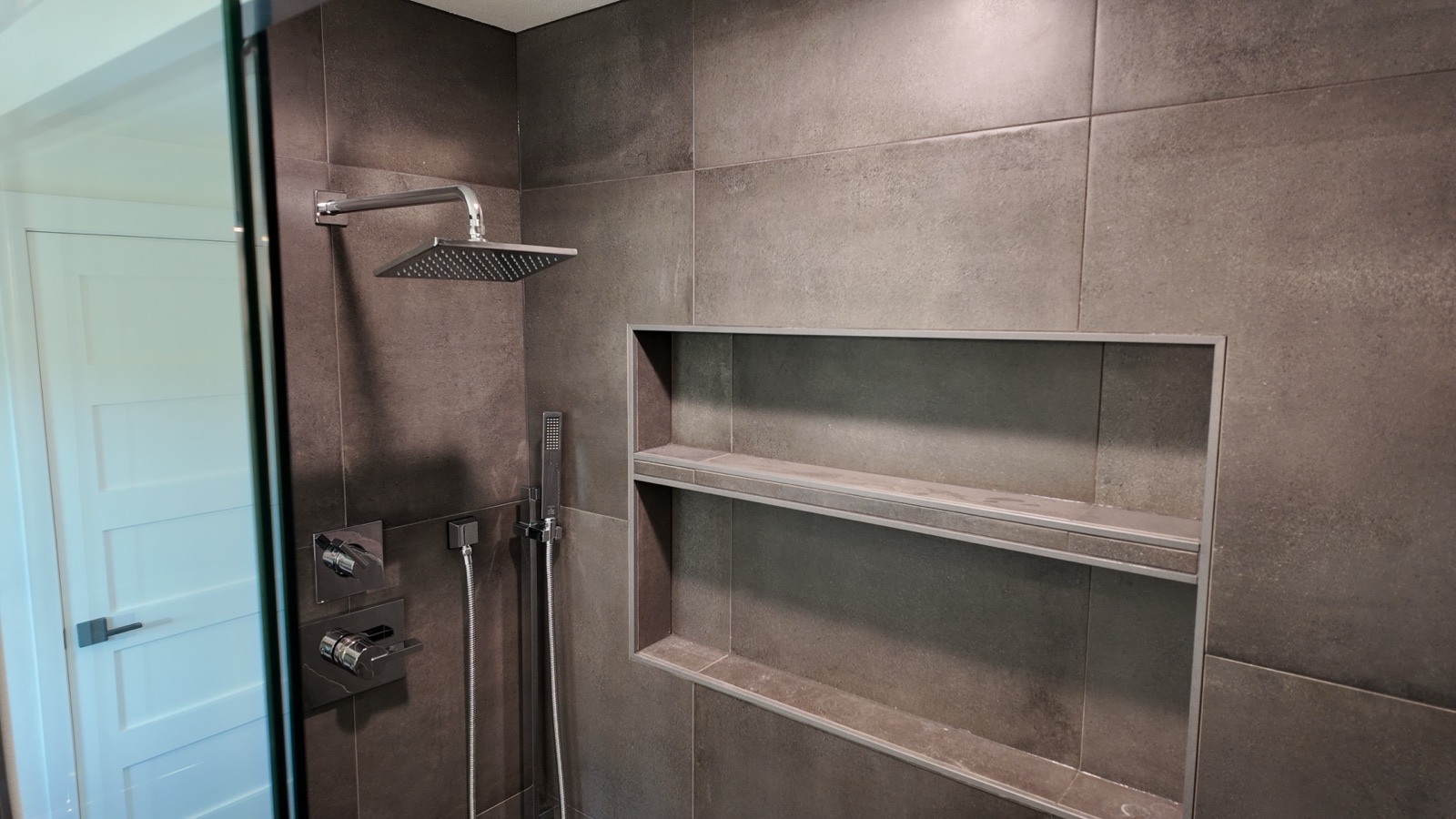 Modern full bathroom with large-format gray tile and a rainfall shower head
