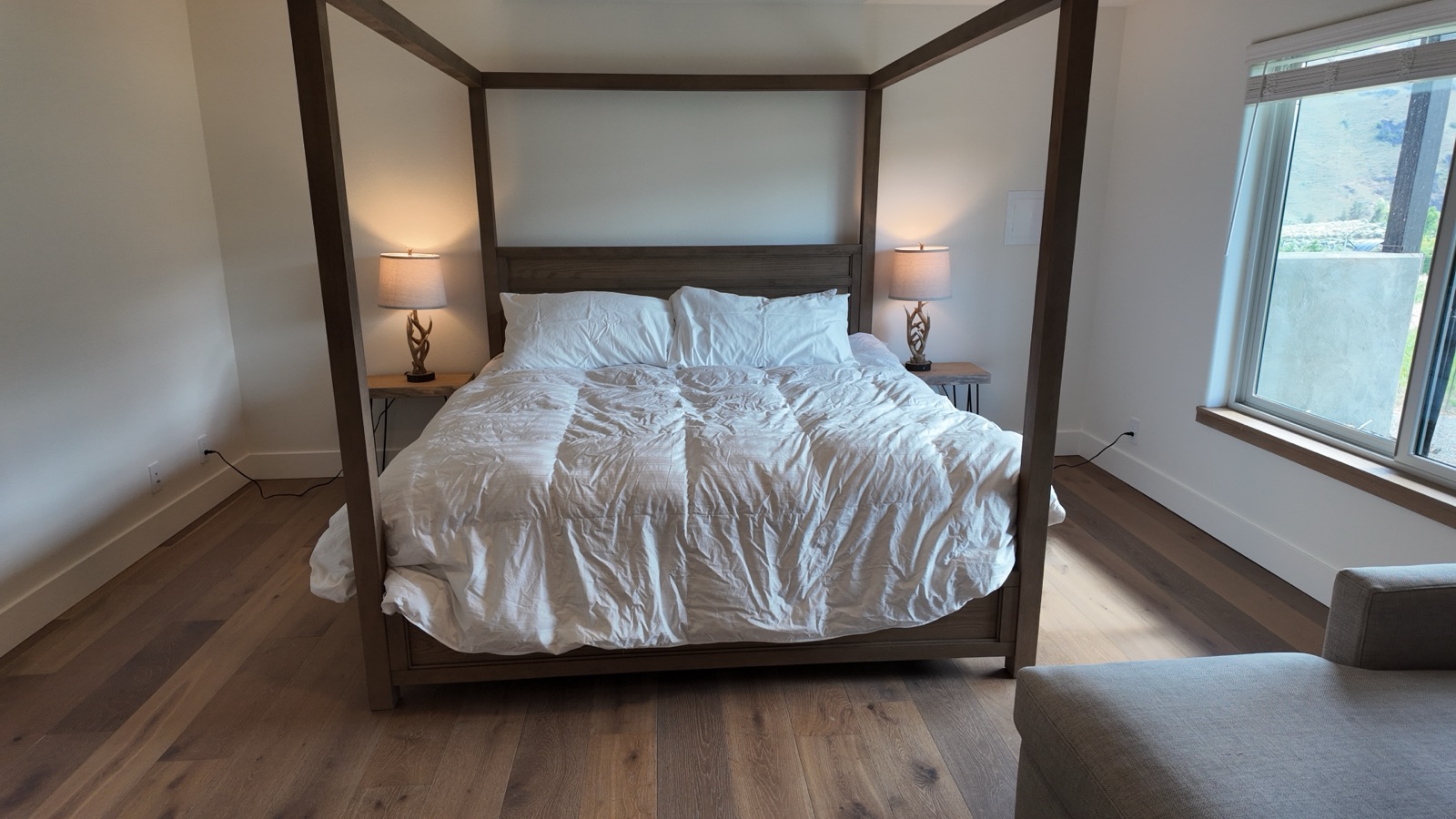 Downstairs king suite with a wood canopy king bed, antler lamps and a Yakima River Canyon view window